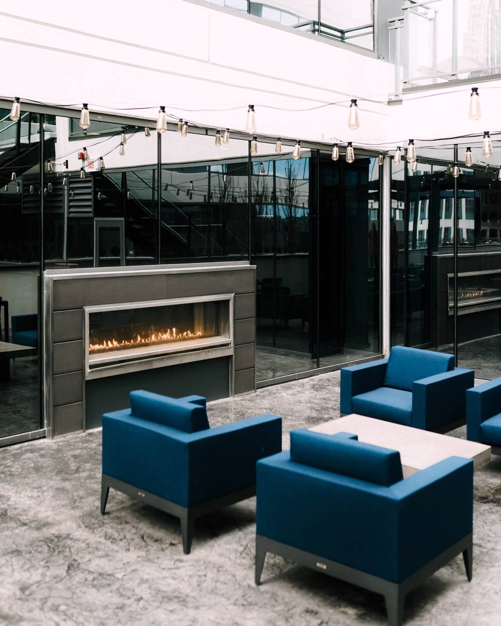 a modern living room with blue couches and a fireplace at The Grand Central, Chicago