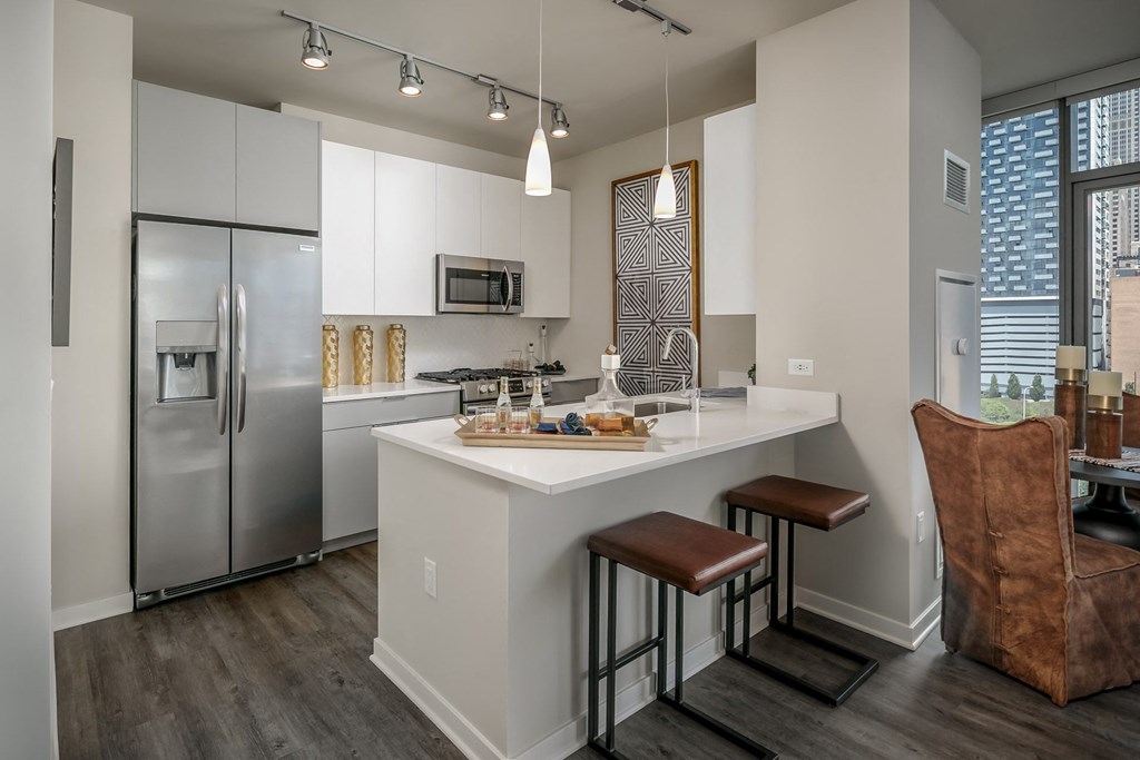 a kitchen with a large island and stainless steel refrigerator at The Grand Central, Illinois, 60607