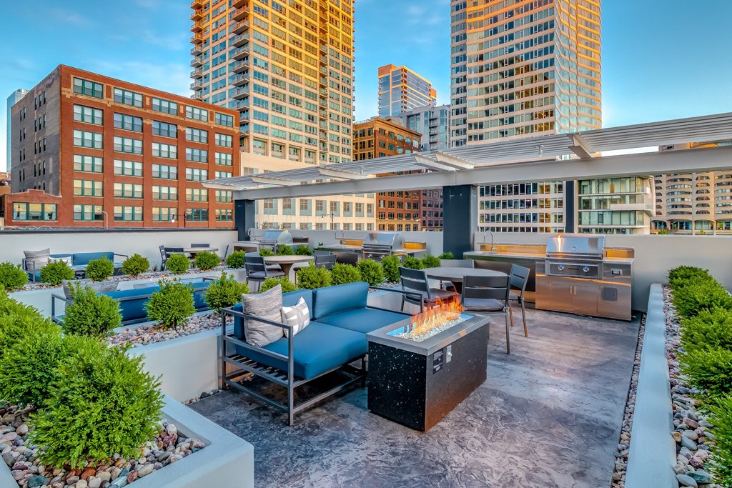 a rooftop patio with a fire pit and a city skyline at The Grand Central, Chicago, IL