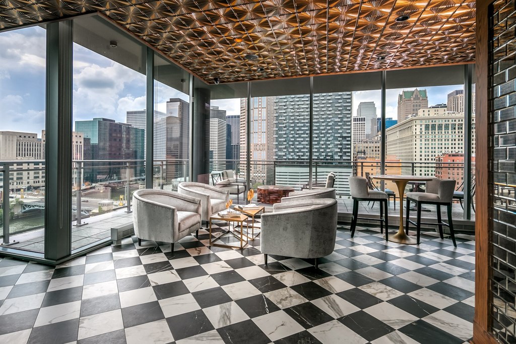 a room with a view of the city and a checkered floor and tables at The Grand Central, Chicago, IL 60607