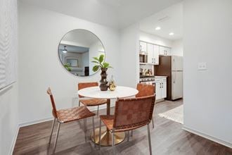 a dining room with a table and chairs and a round mirror