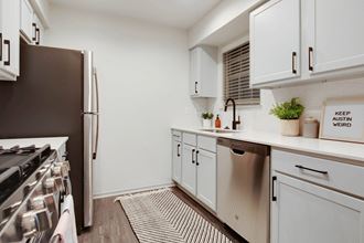 a kitchen with white cabinets and a stainless steel refrigerator