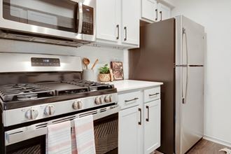 a kitchen with stainless steel appliances and white cabinets