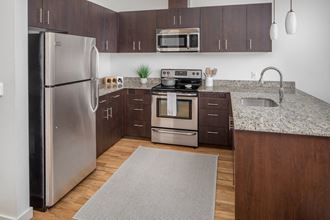 a kitchen with stainless steel appliances and granite countertops at The Parker, Portland