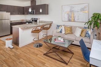a living room and kitchen with plank flooring at The Parker, OR 97209 - Photo Gallery 4