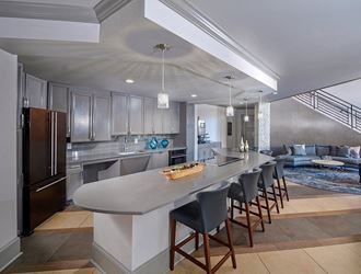 a kitchen with a long island with chairs