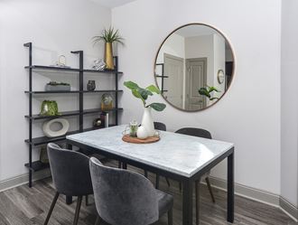 a dining room with a table and chairs and a mirror