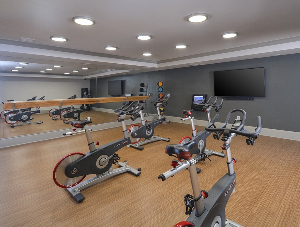 a gym with various exercise bikes and a television at The Tribute, Raleigh, NC