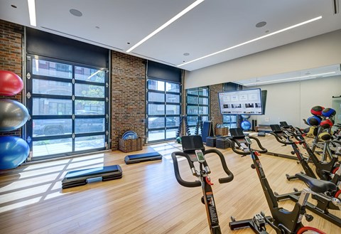 A gym with a brick wall and wooden floors. at The Mason Apartments, Chicago, IL
