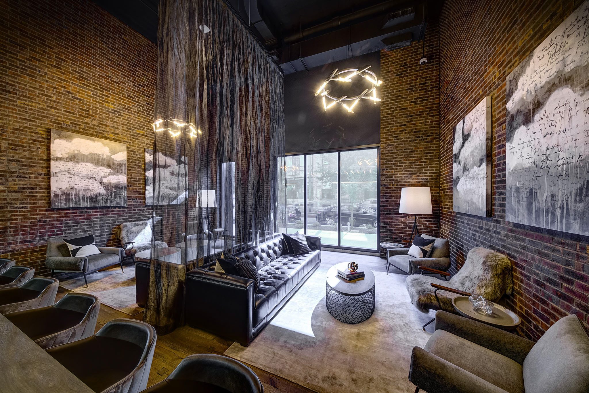 A living room with a black couch and a large window.