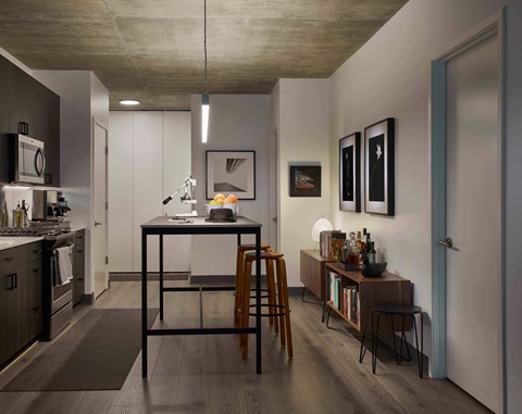 A modern kitchen with a dining table and chairs. at The Mason Apartments, Chicago