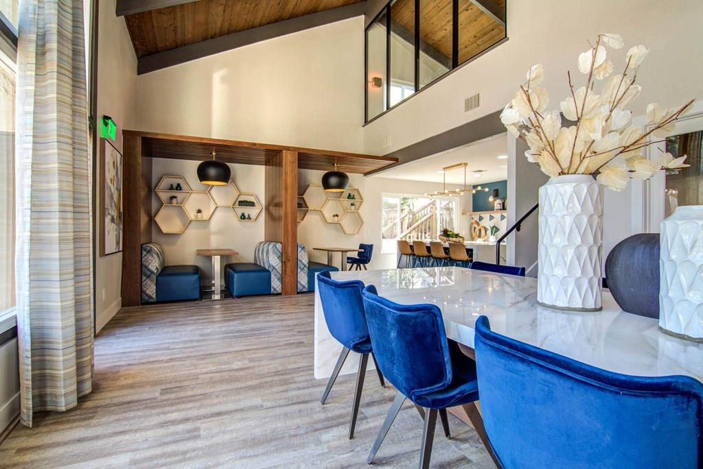 a dining room table with blue chairs and a vase of flowers  at Veranda La Mesa, La Mesa