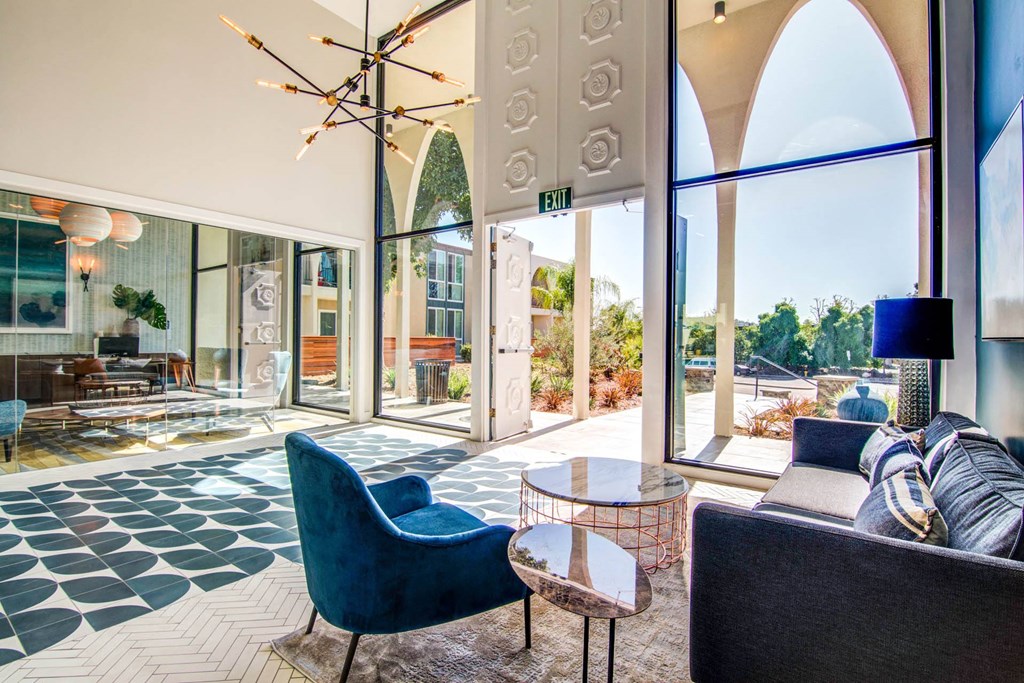 a living room with blue chairs and a chandelier  at Veranda La Mesa, La Mesa