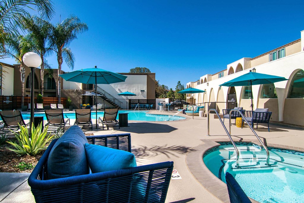 a patio with a pool and chairs and umbrellas  at Veranda La Mesa, California