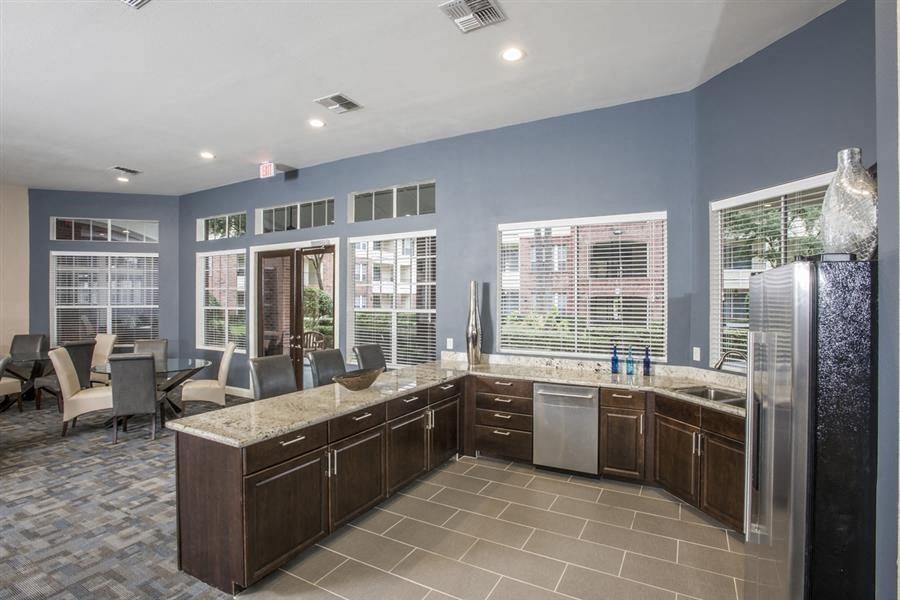a large kitchen with a sink and a refrigerator at Veranda at Centerfield, Houston