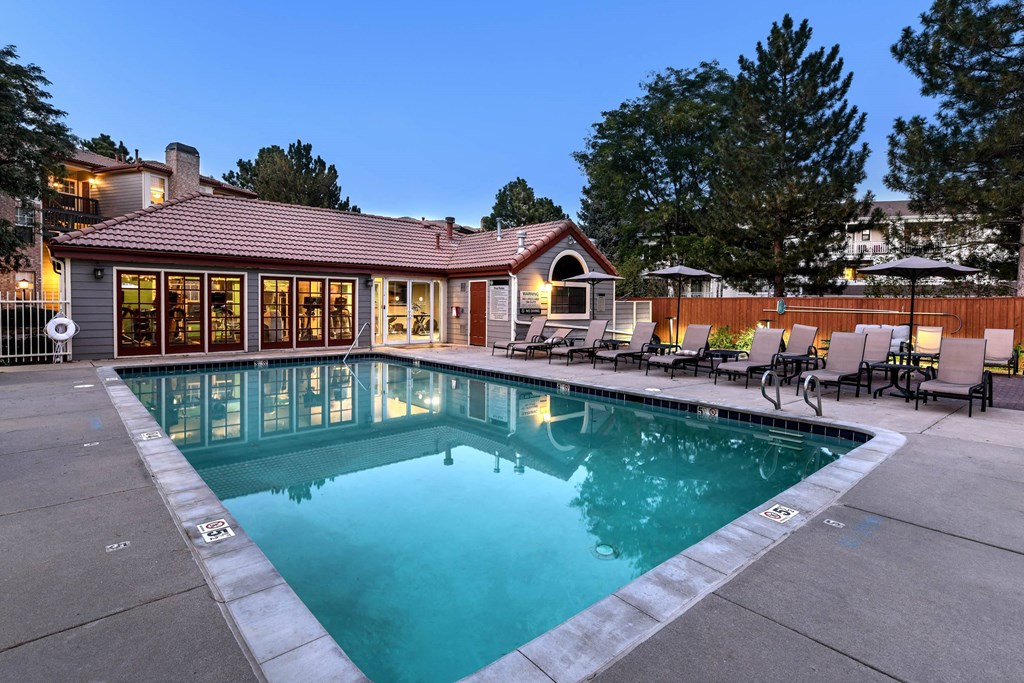 a pool with chairs and a house in the background at Verdant, Colorado