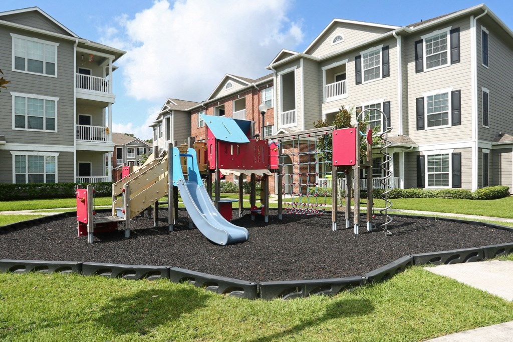 an outdoor playground in front of an apartment building