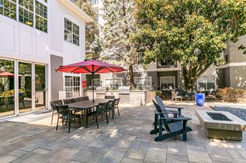 a patio with tables and chairs and a red umbrella at Willowest in Lindbergh, Georgia