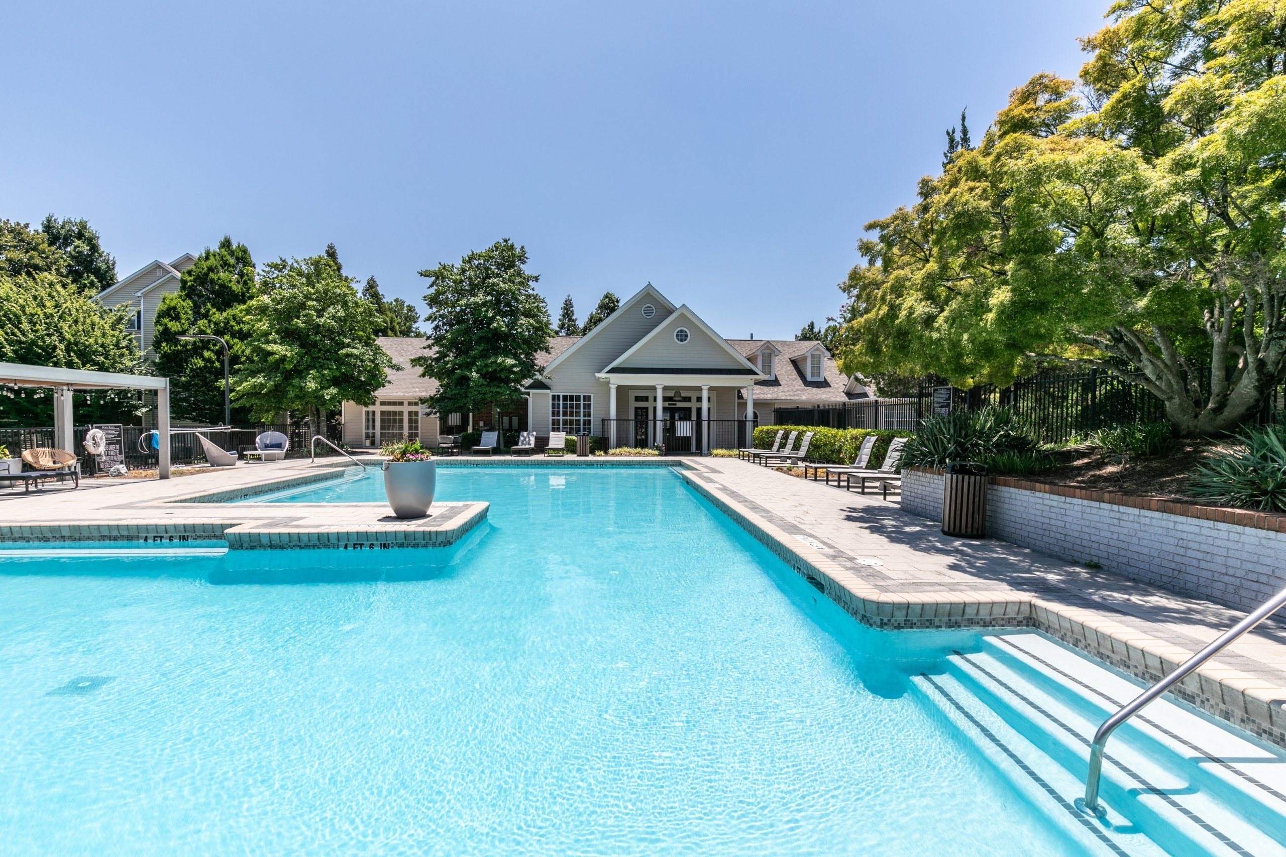 a large swimming pool with a house in the background