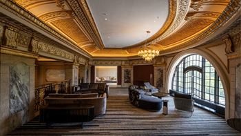 a large room with couches and chairs and a chandelier  at The Belden Stratford, Chicago