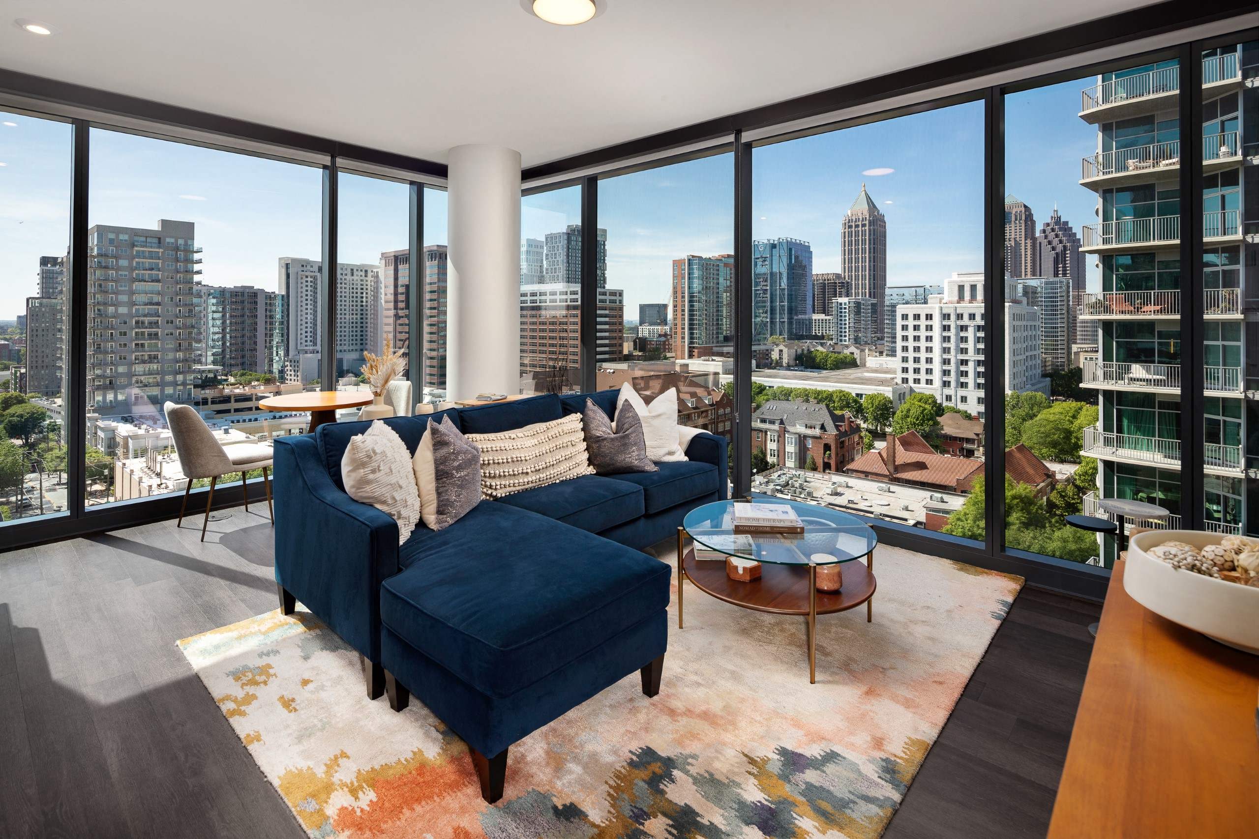 a living room with a blue couch and a view of the city