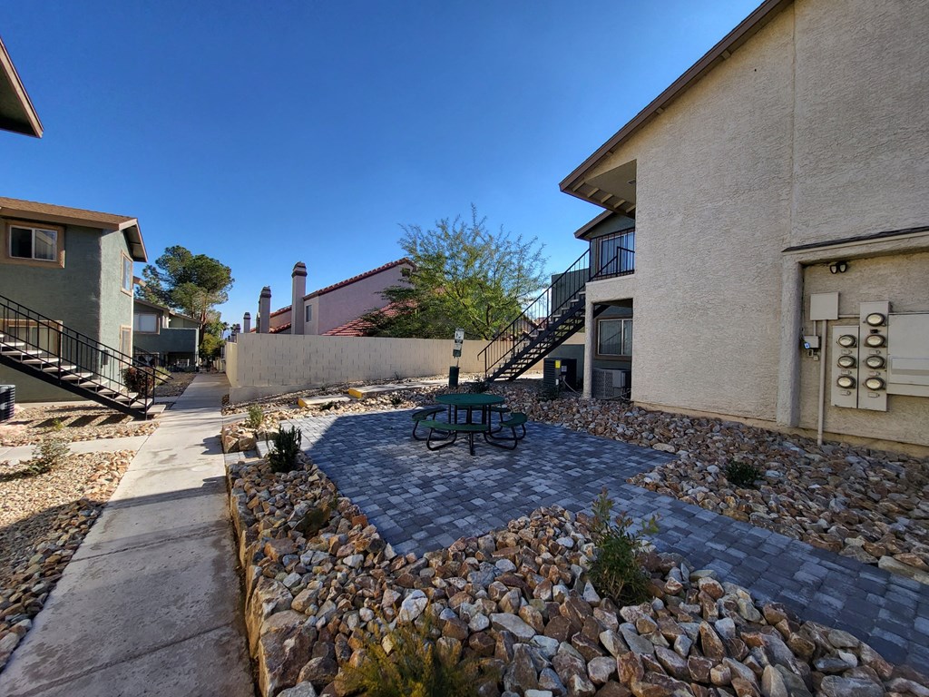 a courtyard with a picnic table in front of a building at Sunset Winds Apartments in Nevada 89014