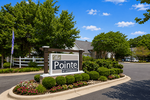 A sign that says "The Pointe at Wimbledon" in front of a building.