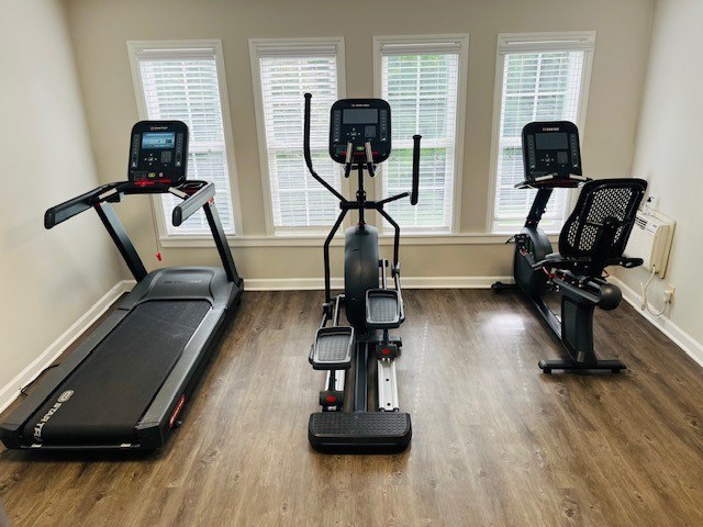 Three exercise machines are lined up in a room.