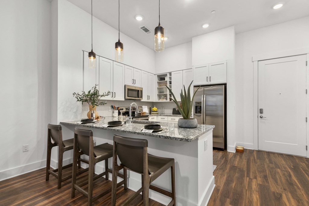 a kitchen with a large island with three stools at The Colony, Charlotte, 28211