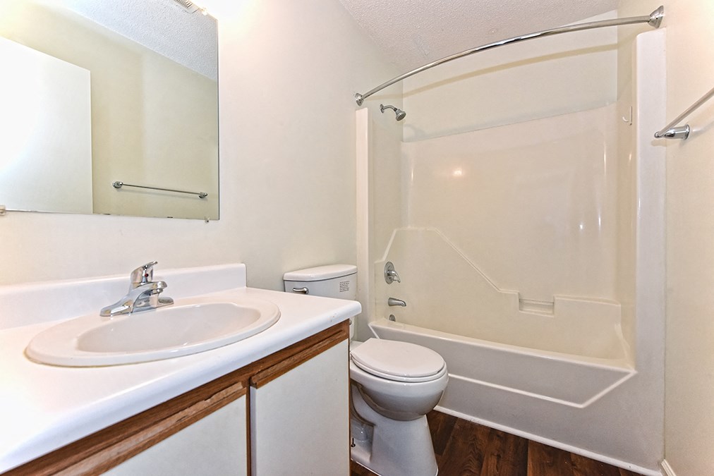 A white sink with a silver faucet is on a countertop in a bathroom.