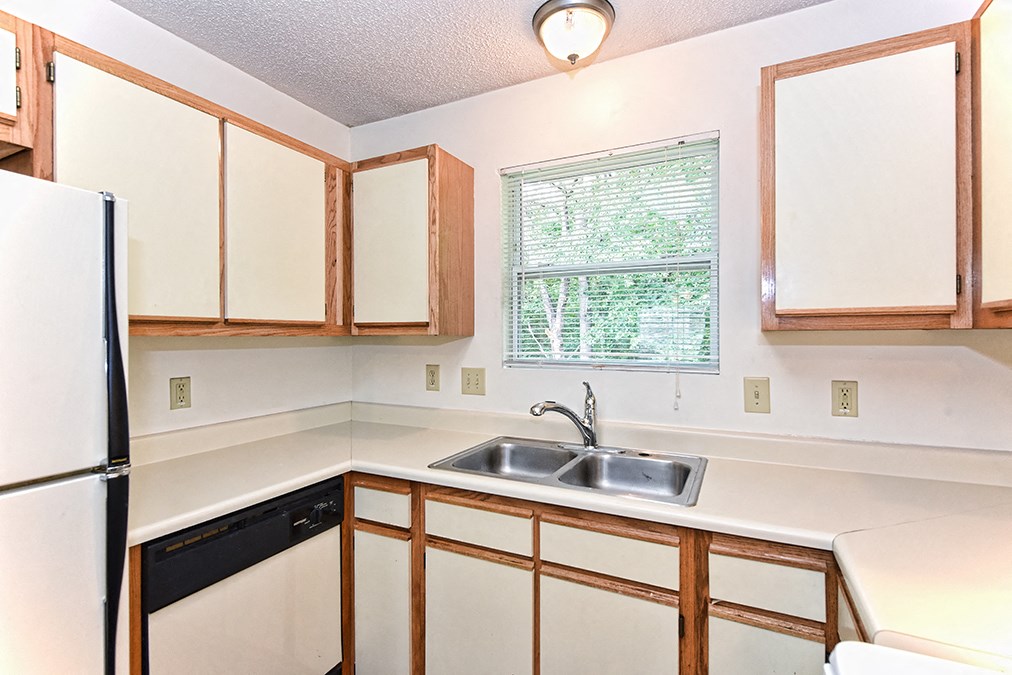 A kitchen with a sink and a refrigerator.