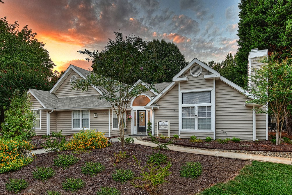 a home with a landscaped front yard and a cloudy sky
