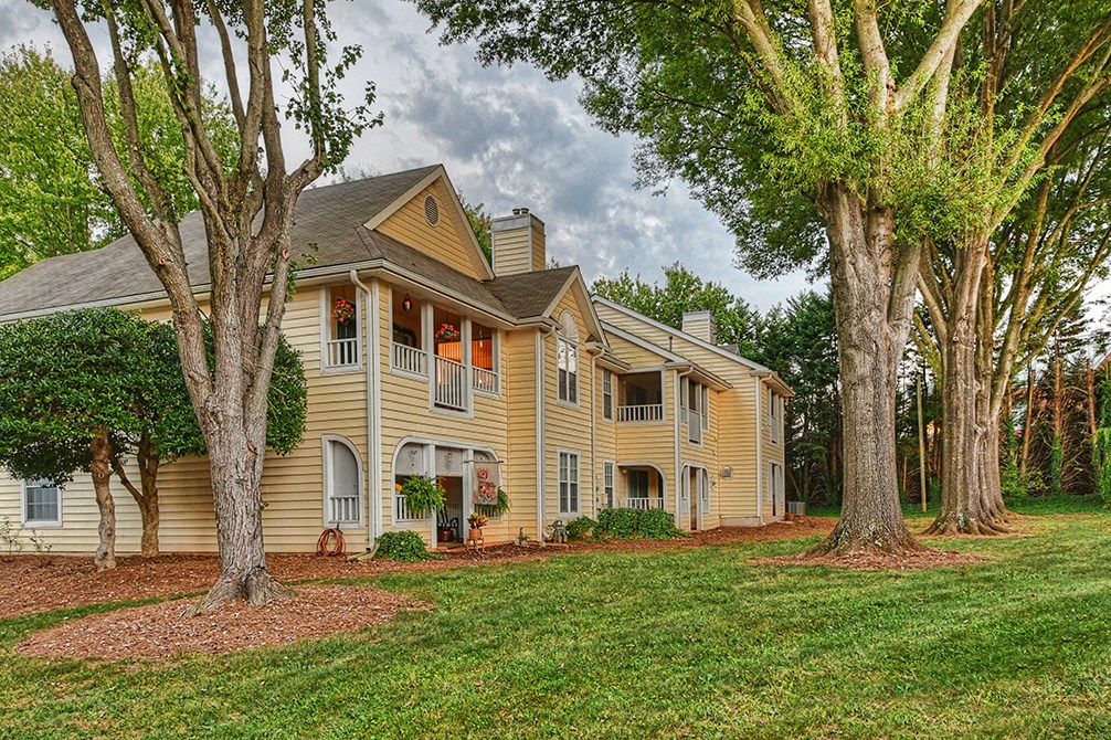 a large yellow house with trees in front of it