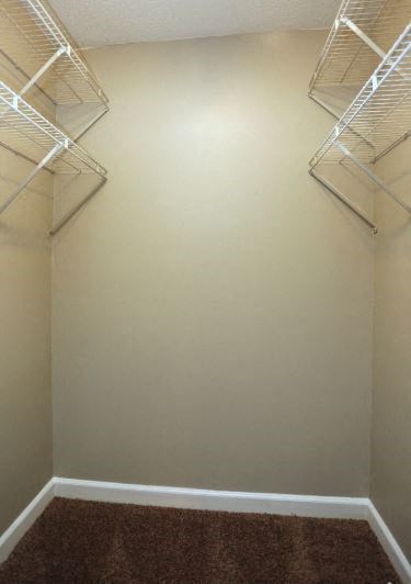 an empty closet with empty shelves on the wall