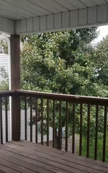 a porch with a view of trees and a house