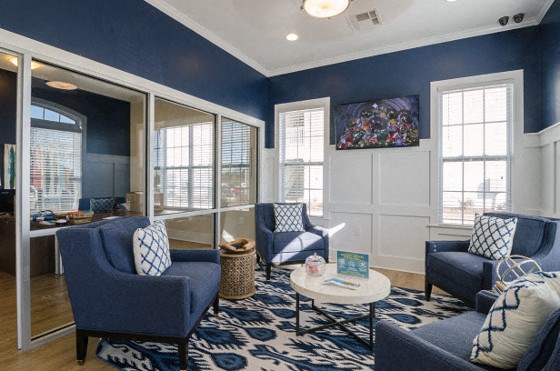 a living room with blue couches and chairs and a coffee table