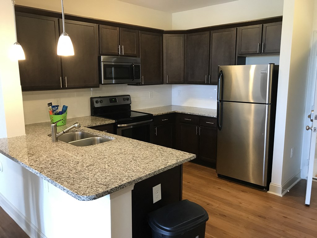 a kitchen with granite counter top and stainless steel refrigerator