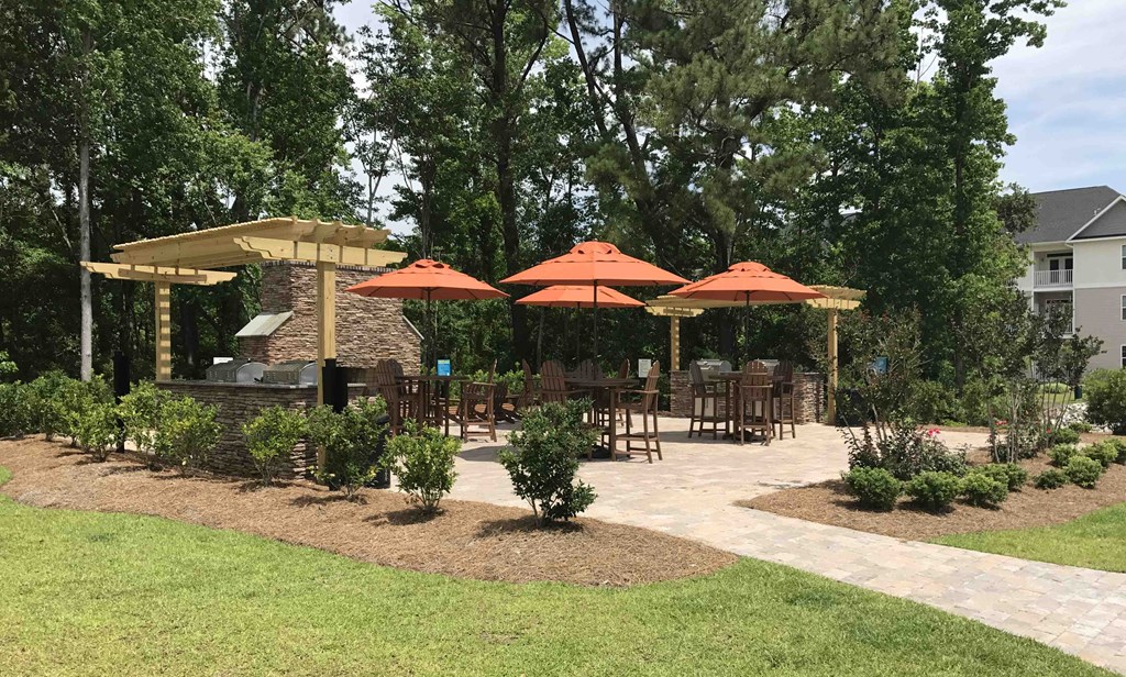 a patio with umbrellas and tables in a backyard