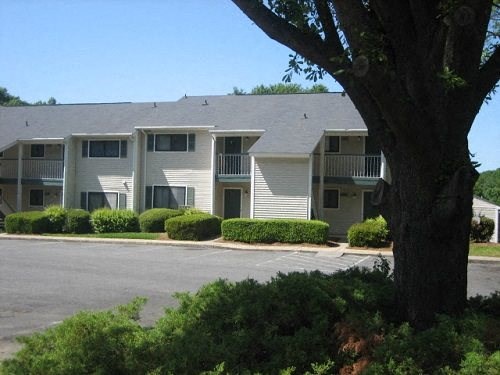 an apartment building with a tree in front of it