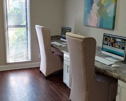 a home office with two chairs at a desk with computers