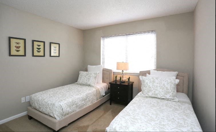 a bedroom with two beds and a window