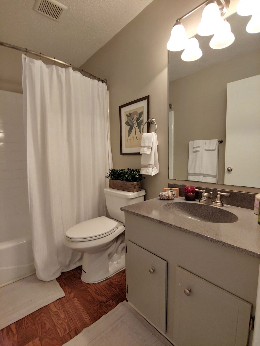 a bathroom with a white shower curtain and a toilet and sink