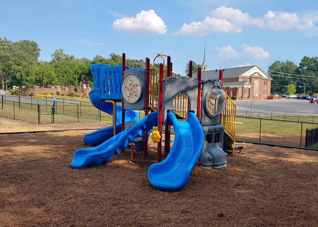 a playground at a park with slides and a clock
