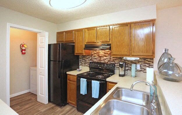a kitchen with a black refrigerator and a sink