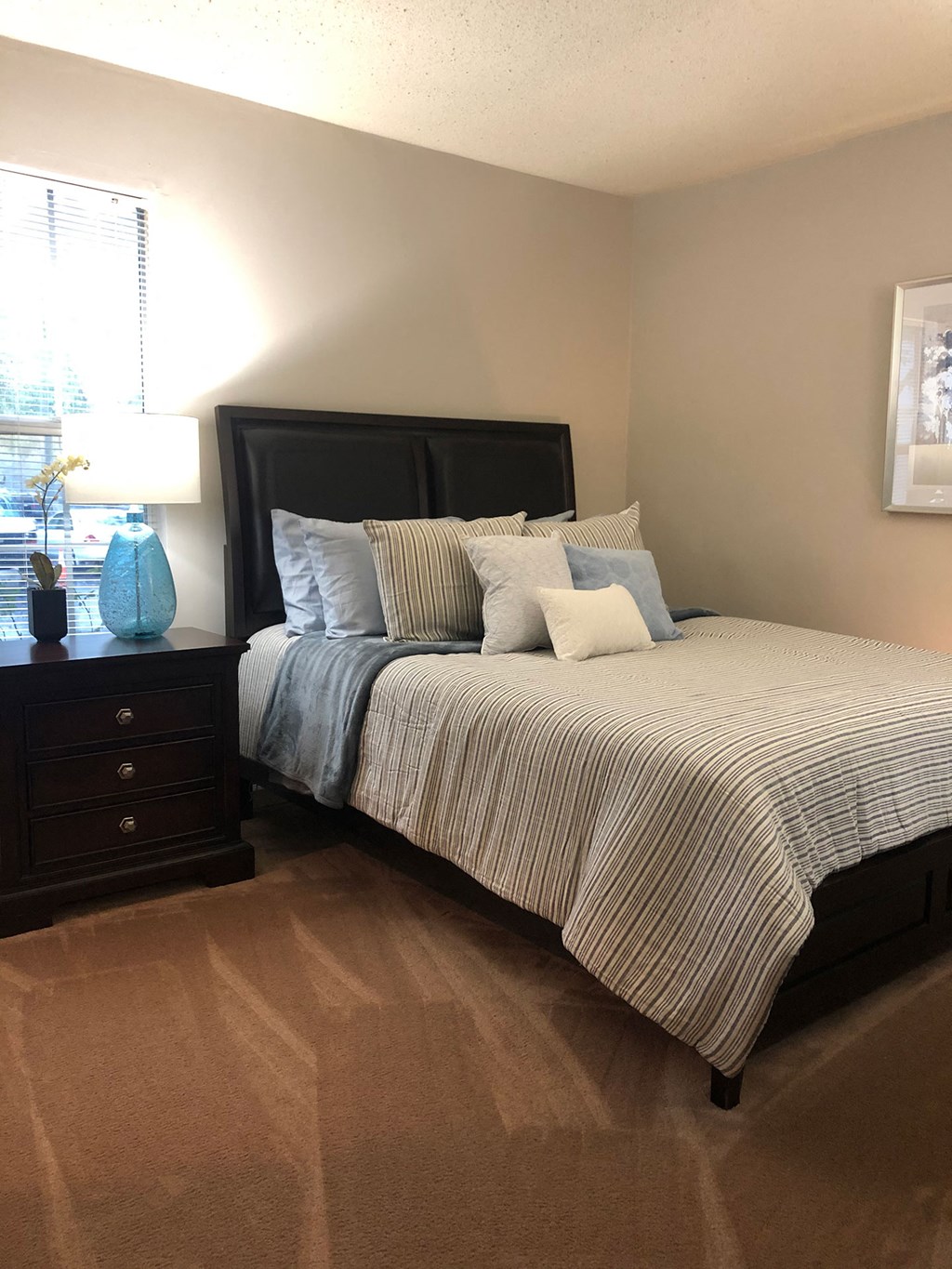 a bedroom with a bed and a dresser and a window
