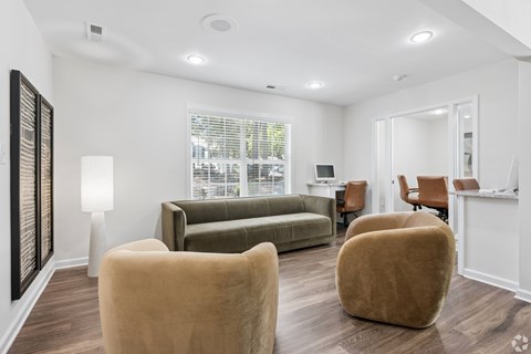 A living room with a couch, two chairs, and a table.