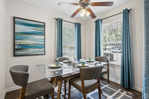 A dining room with a glass table and chairs.