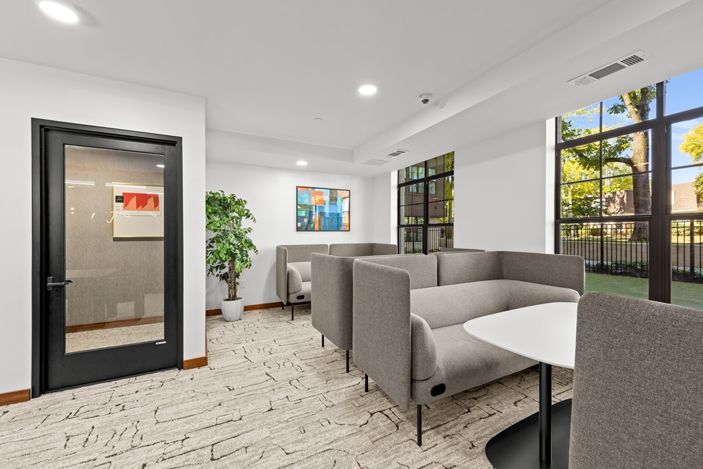 A modern waiting room with grey couches and a black table.