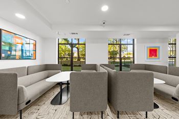 A conference room with a table surrounded by grey chairs.