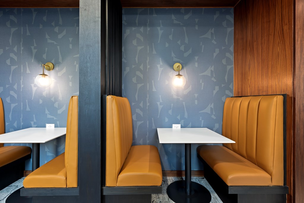 A restaurant with orange booths and tables.